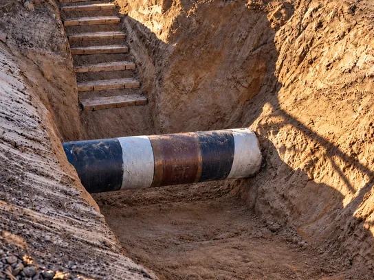 Cañería descubierta en una excavación de verificación, con el revestimiento a la vista.