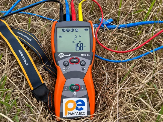 Telurímetro con cuatro cables conectados en el campo y la lectura de la resistencia en pantalla.